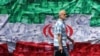 A man walks past an Iranian flag installed along a roadside in Tehran on April 29.