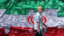 A man walks past an Iranian flag installed along a roadside in Tehran on April 29.