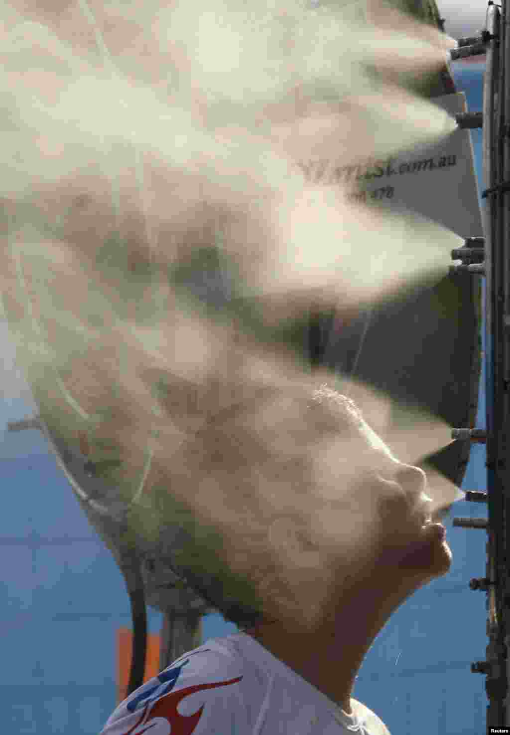 A boy places his face close to the nozzles of a misting fan at the Australian Open on January 15.