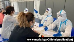 Коронавирусты емдейтін ауруханада медицина қызметкерлері тұрғындардың денсаулығы жайлы сұрап жатыр. Шілде айы, 2020 жыл.