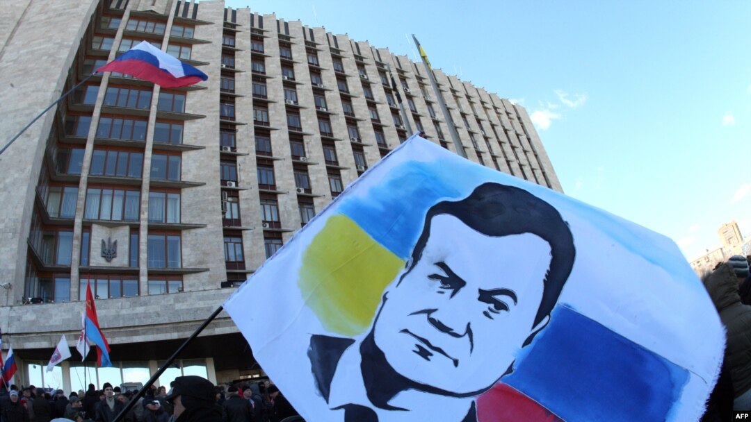 A demonstrator holds a flag with a portrait of ousted Ukrainian President Viktor Yanukovych during a rally of pro-Russia supporters outside the regional government administration building in the center of the eastern Ukrainian city of Donetsk on April 5. 