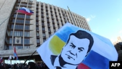 A demonstrator holds a flag with a portrait of ousted Ukrainian President Viktor Yanukovych during a rally of pro-Russia supporters outside the regional government administration building in the center of the eastern Ukrainian city of Donetsk on April 5. 