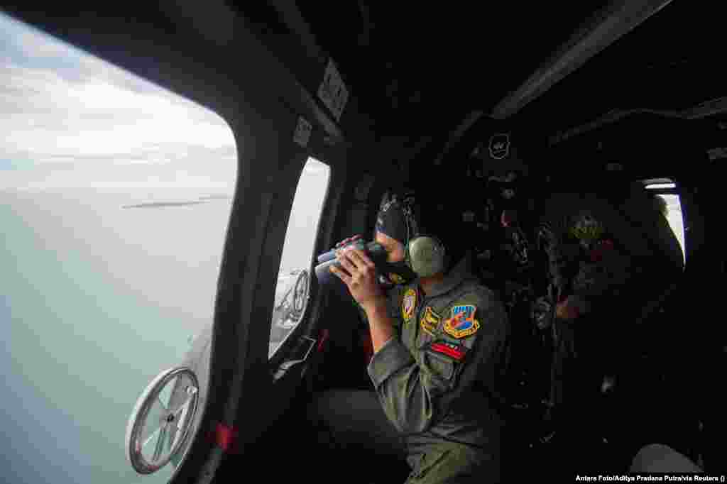 Az&nbsp;indonéziai fegyveres erők egy munkatársa egy helikopterből vesz részt a keresésben.