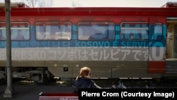Пассажир ждет отправления поезда, украшенного сербскими флагами и расписанного лозунгами «Косово – это Сербия» на 20 языках. Белград, Сербия, март 2018 года