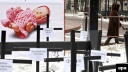 Москвадагы абортко каршы акция - символикалык түрдө жасалган мүрзөдө "айдоочу", "башкы редактор", "архитектор" деген сөздөр жазылган. 2008-жылдын 28-январы.