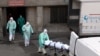 Коронавирустан көз жумган адамдын сөөгүп алып бараткан медкызматкерлер. Испания. 25-март, 