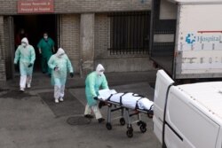 ესპანეთი, სამედიცინო პერსონალს კორონავირუსით გარდაცვლილი ადამიანი მიჰყავს, 25 მარტი.