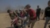 Palestinski demonstranti nose ranjene tokom sukoba u blizini granice sa Izraelom na istoku Gaze.
