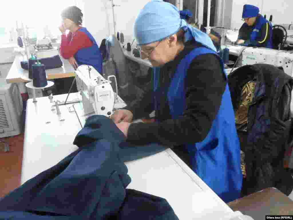 Женщины в швейном цехе шьют спецодежду.
