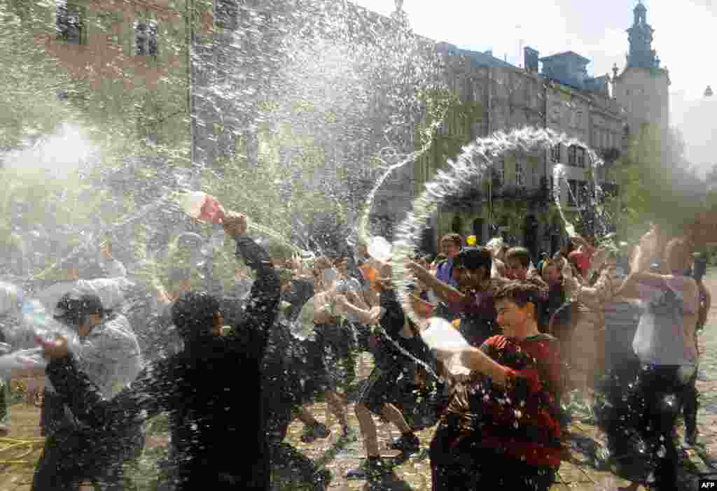 People spray water on one another in the western Ukrainian city of Lviv in a bit of traditional Easter horseplay on "Wet Monday." (AFP/Yuriy Dyachyshyn)
