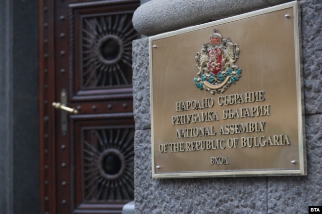Табела с държавния герб, поставена до вход на бившия Партиен дом