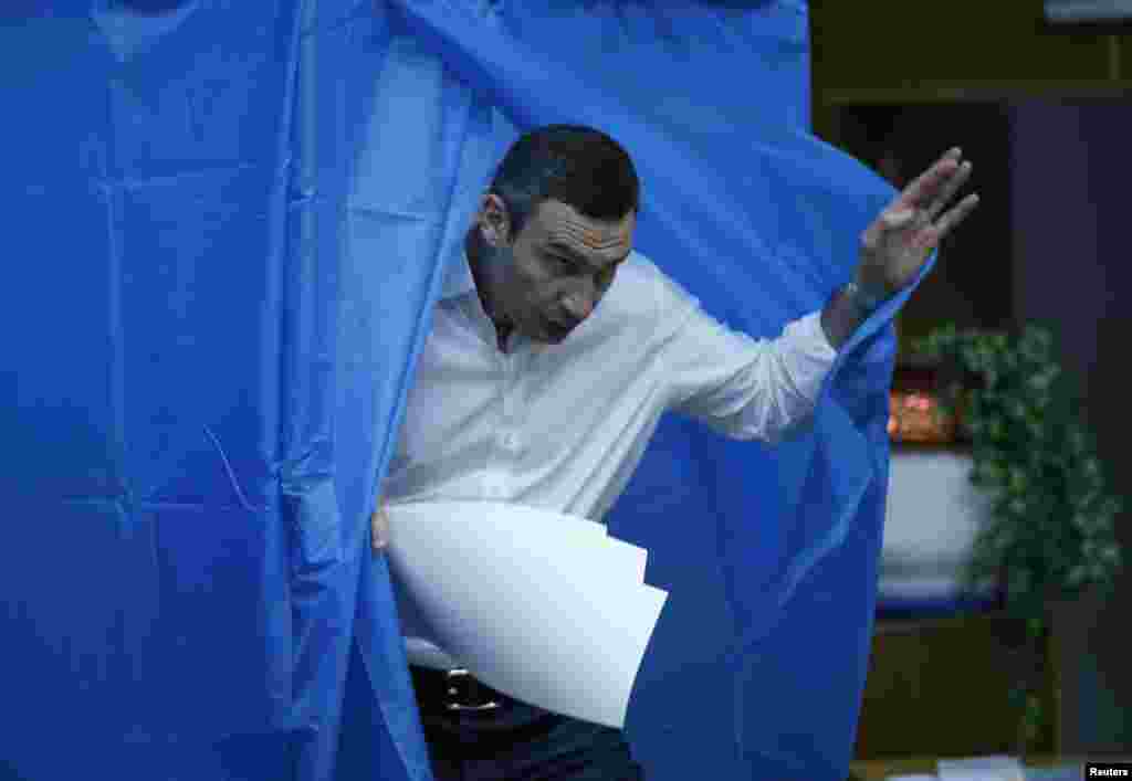 Heavyweight boxing champion and UDAR (Ukrainian Democratic Alliance for Reform) party leader Vitali Klitschko leaves a booth before casting his vote at a polling station in Kyiv.