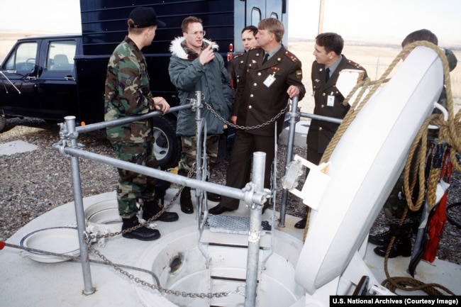 A U.S. Army interpreter translates for Russian Strategic Rocket Forces colonels at the entrance to an access shaft into a Minuteman III nuclear missile silo.