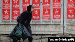 O alegătoare trecând pe lângă un panou electoral. 21 februarie 2019