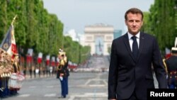 France - France's President Emmanuel Macron walks on the day of the annual Bastille Day military parade on the Champs-Elysees avenue in Paris, July 14, 2023. 