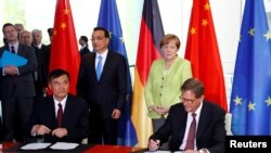Angela Merkel (arxada sağda) və Li Keqiang, arxiv fotosu