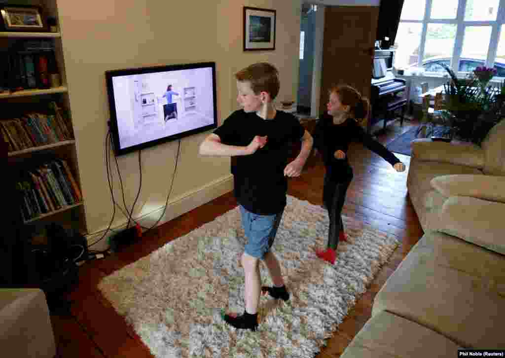 Alice and Joseph Wilkinson take part in a physical-education class at their home in Manchester England.&nbsp; 