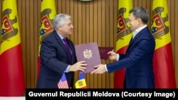 Noul șef al Misiunii USAID în R. Moldova, John Allelo (s.), și prim-ministrul R. Moldova, Dorin Recean, după semnarea acordului de grant oferit de agenția americană, Chișinău, 15 ianuarie 2025.