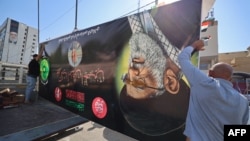 کارگران عراقی در حال آماده‌سازی پوستر علی خامنه‌ای، رهبر کشته‌شدهٔ جمهوری اسلامی، یک روز پیش از مراسم تشییع جنازهٔ او در شهر کربلا در ۱۶ تیرماه هستند