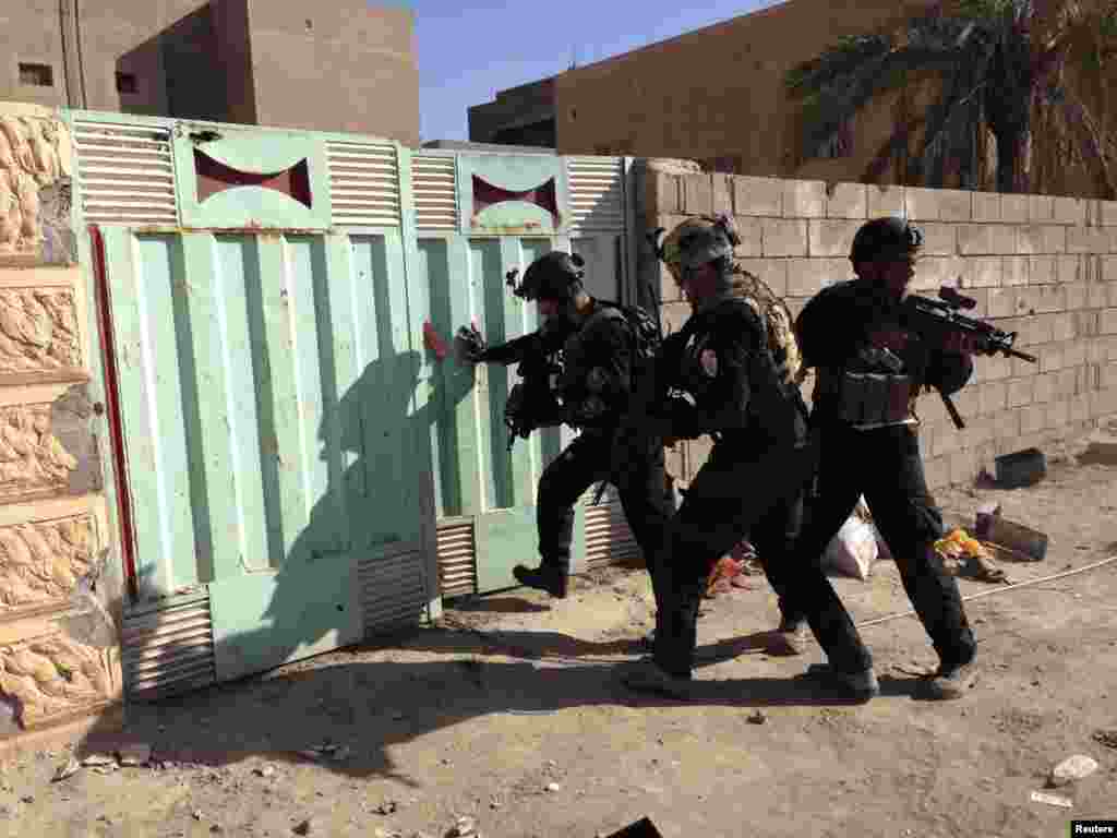 Iraqi security forces search for weapons in a compound in Ramadi.