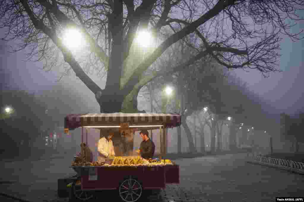 Street vendors sell corn on Sultanahmet Square near the Blue Mosque on a foggy day in Istanbul. (AFP/Yasin Akgul)