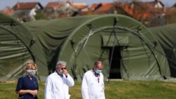 Medicinsko osoblje s maskama za lice u blizini vojnih šatora koji su postavljeni za pacijente oboljele od COVID-19, bolnica Dubrava u Zagrebu, 28 mart 2020