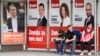 People wait at a bus stop draped in election posters in the Bosnia capital, Sarajevo, late last month. 