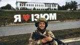 UKRAINE – A Ukrainian soldier smiles in front of a city sign reading ''I Love Izium'' in Izium, Kharkiv region, September 13, 2022