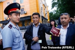 Сотрудники полиции задерживают журналиста Бакытжана Косбармакова в центре Алматы. 12 июня 2019 года