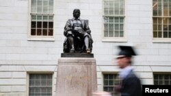 Student prolazi pored statue Johna Harvarda na dan 374. svečane dodjele diploma na Univerzitetu Harvard u Cambridgeu, Massachusetts, SAD, 29. maja 2025. 