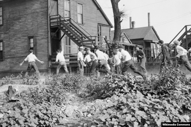Разъяренная толпа забивает камнями жертву. Фото из газеты Werst Virginian. 31 июля 1919.