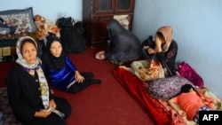 An Afghan family sits in an International Organization for Migration transit center in the western Herat Province after returning from Iran on August 2. 