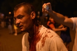Волонтер оказывает помощь пострадавшему от действий ОМОНа в Минске, 10 августа 2020 года