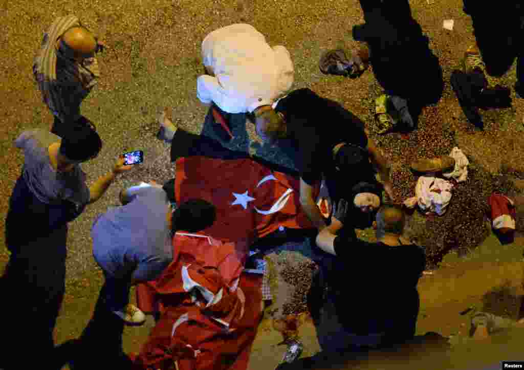 An injured woman draped in a Turkish flag is checked by others near military headquarters in Ankara. The state-run Anadolu Agency reported that seven police officers were killed at their Ankara special forces headquarters.