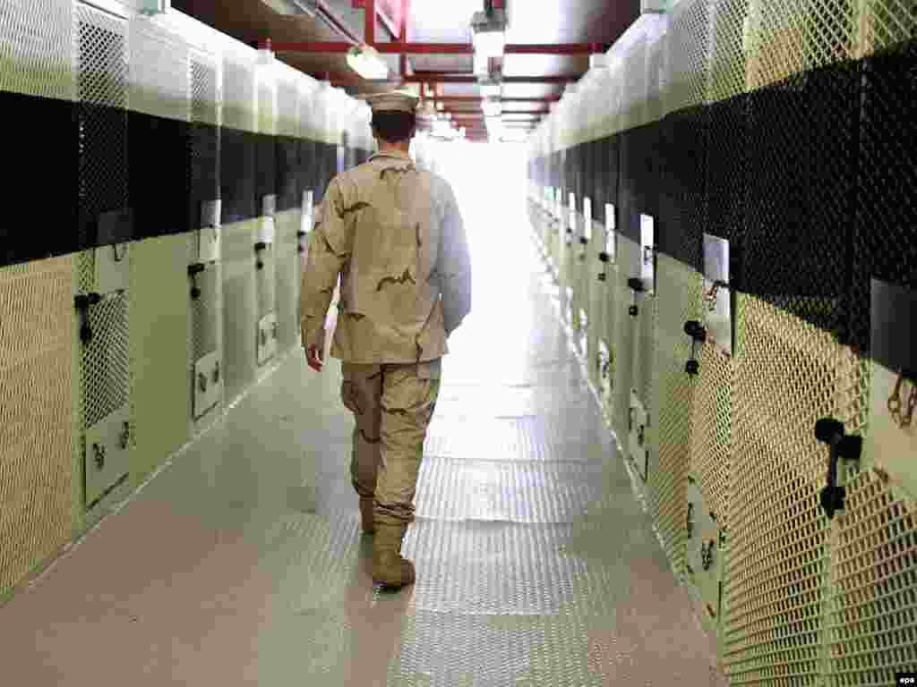 A U.S. soldier walks through a cell block in Camp Delta at Guantanamo Bay.