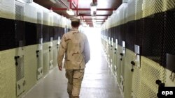 File photo of a U.S. walking through a cell block in Guantanamo Bay.