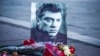 Цветы перед траурным фото с изображением Бориса Немцова. 27 февраля 2016 года.