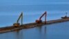 Экскаваторы делают насыпи в водной акватории Керченского пролива для строительства моста