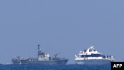An Israeli military vessel (left) escorts one of the boats in a Gaza-bound aid convoy with Israeli troops on board to the southern Israeli port of Ashdod.