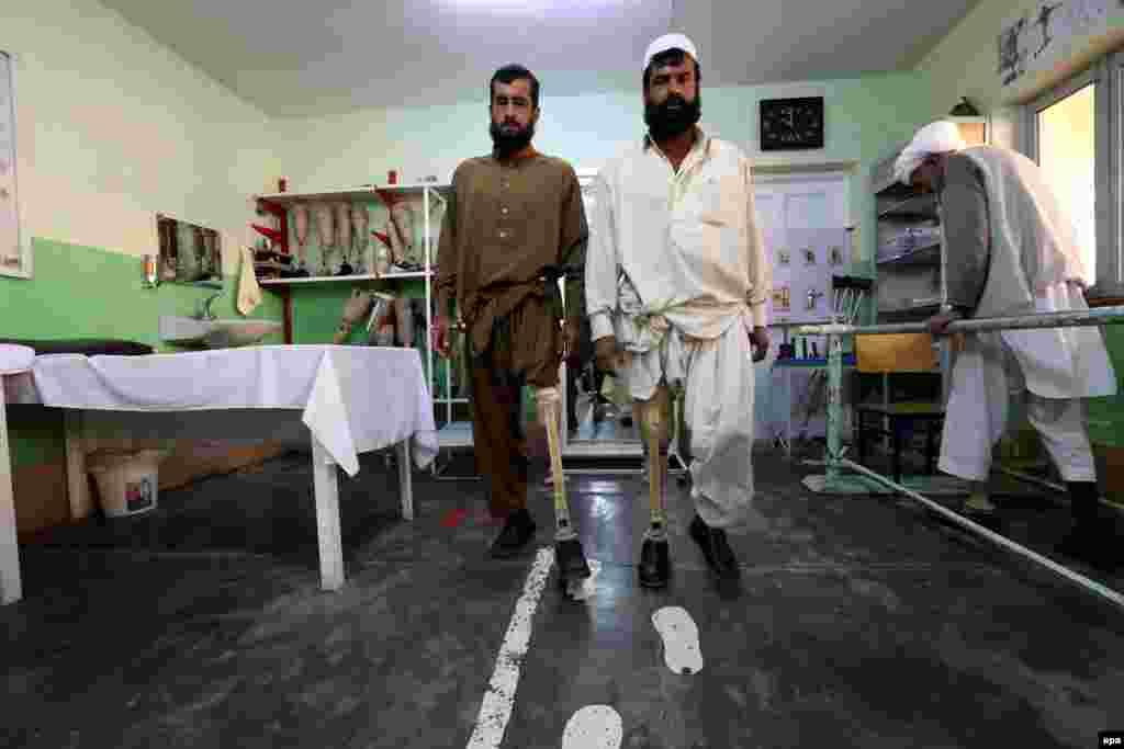Afghan men who lost their limbs in land-mine blasts practice with their new prosthetic limbs at an International Committee of the Red Cross center in Herat. After almost three decades of war, the countless mines that remain buried in Afghanistan still kill or maim dozens of people every month. As well as being a place for treatment, the Herat center is a small factory where production lines churn out hundreds of prostheses every month. (epa/Jalil Rezayee)