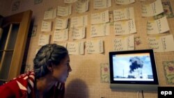 Një grua duke shikuar programin e lajmeve, Rusia 24, gjatë sulmeve ajrore në Siri. Forografi nga arkivi.