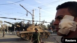 An anti-Morsi protester who was injured during clashes on November 5 with members of the Muslim Brotherhood, stands near a barbed wire barricade in front of the presidential palace in Cairo.