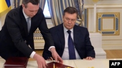 Виктор Янукович подписывает документ, который не хотел бы подписывать
