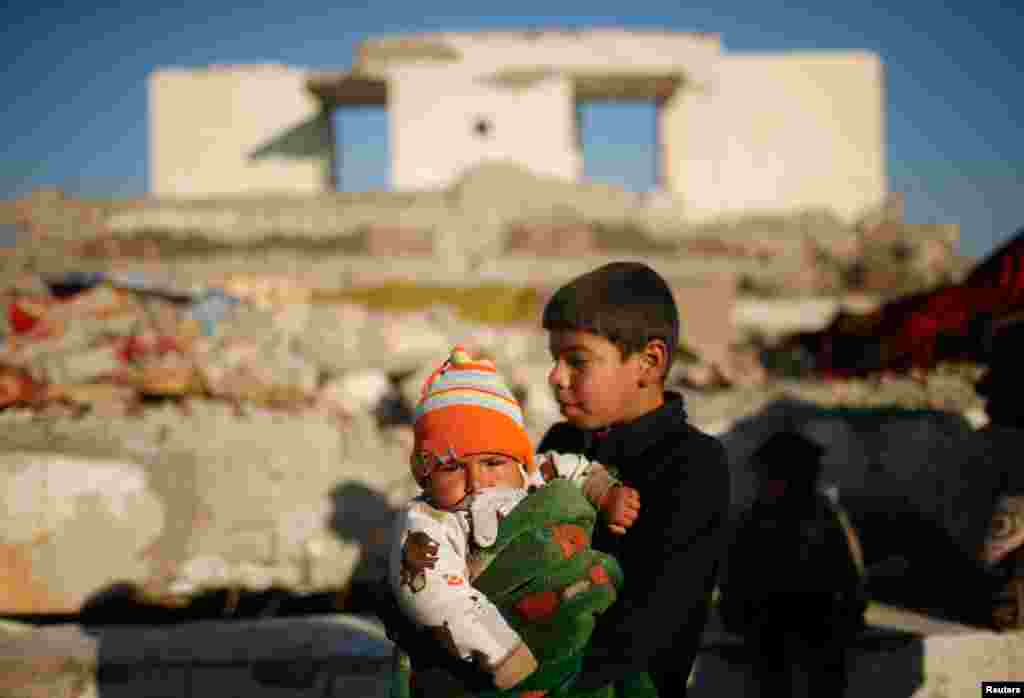 پسر خردسال در آغوش برادرش؛ غرب موصل