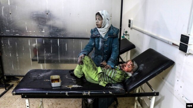 Женщина с ребенком в больнице в районе под контролем повстанцев в пригороде Дамаска, 20 февраля 2017