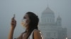 Девушка в защитной маске от смога, окутавшего Москву