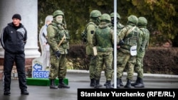Armed Russian military without identification (so-called "little green men") take up position at an airport in Simferopol during the occupation of Crimea in 2014.
