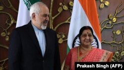 Sushma Swaraj (sağda) və Mohammad Javad Zarif görüşdən öncə