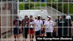 Članovi timova učesnika Olimpijskih igara nose maske u Olimpijskom selu, Tokio (29. juli 2021.)