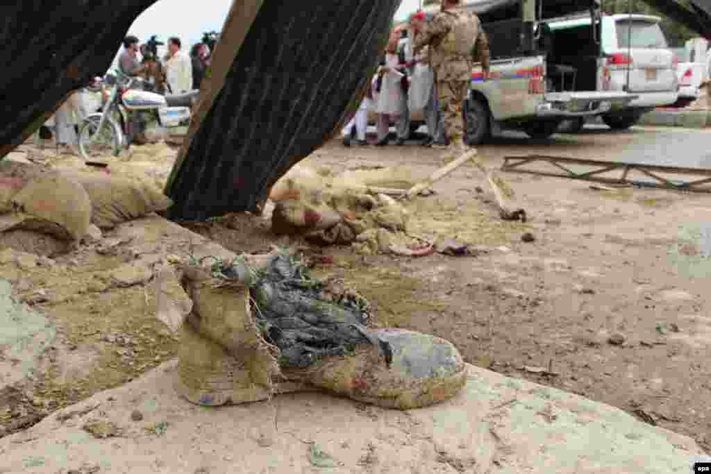 The shoe of one of the victims lies on the ground as Pakistani security officials inspect the site of a bomb blast that targeted a police checkpoint in Quetta on May 10. (epa/Jamal Taraqai)